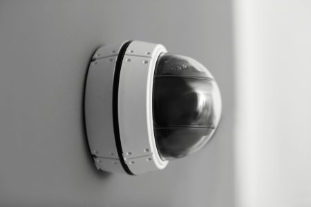 Modern security CCTV camera on grey wall